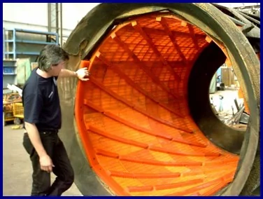 A UMA fitter inspecting a trommel drum lined with moulded polyurethane screen panels